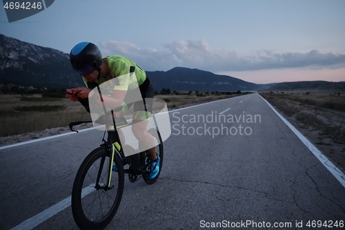 Image of triathlon athlete riding bike at night