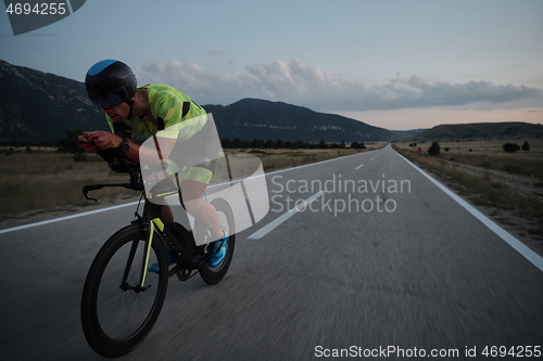 Image of triathlon athlete riding bike at night