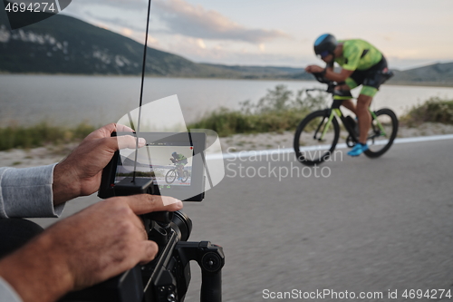 Image of cinematographer taking action shot of triathlon bike athlete