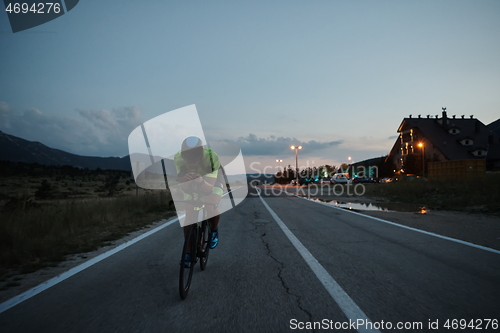 Image of triathlon athlete riding bike at night