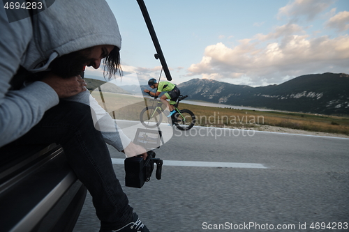 Image of cinematographer taking action shot of triathlon bike athlete