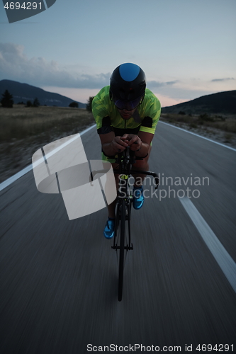 Image of triathlon athlete riding bike at night