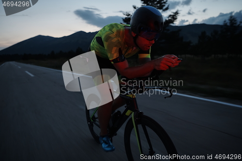 Image of triathlon athlete riding bike at night