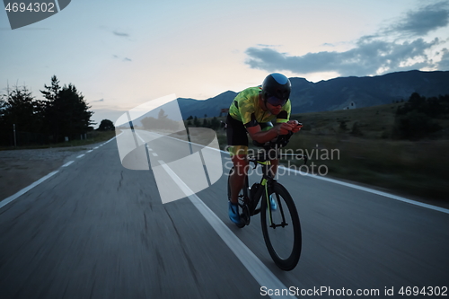 Image of triathlon athlete riding bike at night