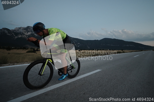 Image of triathlon athlete riding bike at night