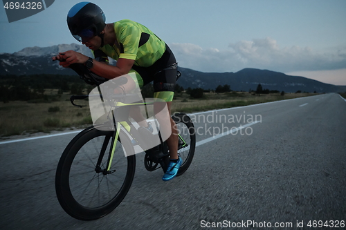 Image of triathlon athlete riding bike at night