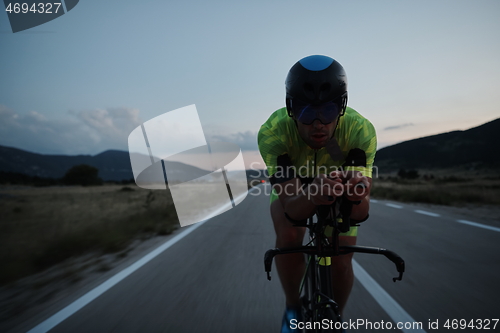 Image of triathlon athlete riding bike at night