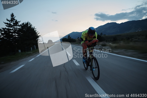 Image of triathlon athlete riding bike at night