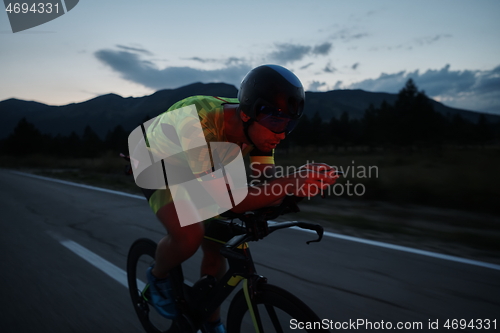 Image of triathlon athlete riding bike at night