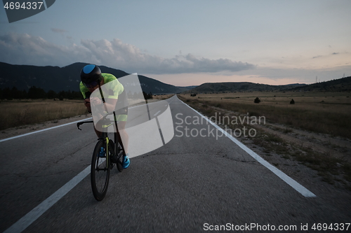 Image of triathlon athlete riding bike at night