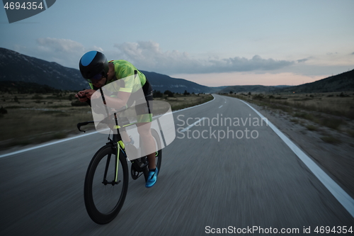 Image of triathlon athlete riding bike at night