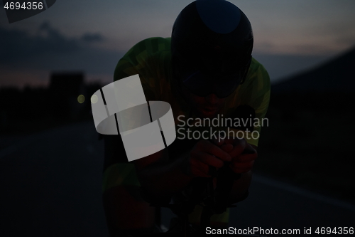 Image of triathlon athlete riding bike at night