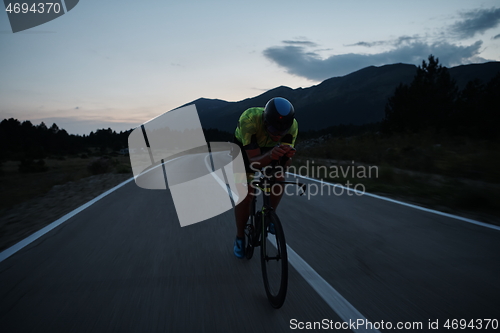 Image of triathlon athlete riding bike at night