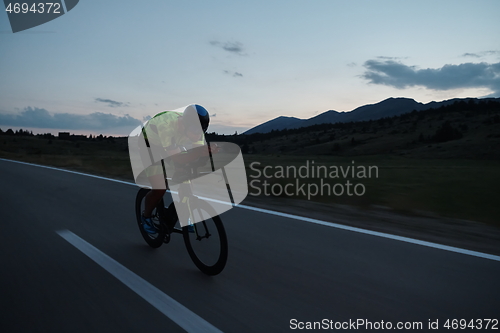 Image of triathlon athlete riding bike at night