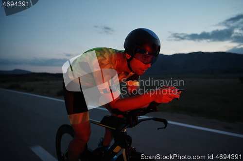 Image of triathlon athlete riding bike at night