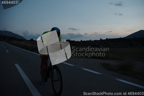 Image of triathlon athlete riding bike at night