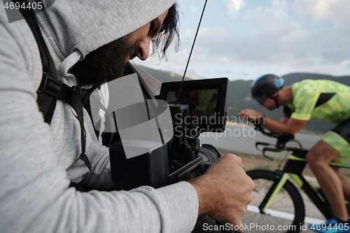 Image of cinematographer taking action shot of triathlon bike athlete