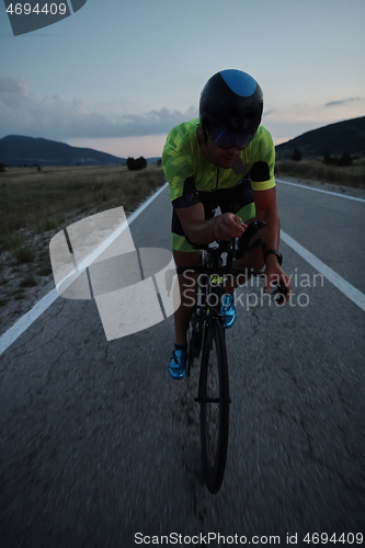 Image of triathlon athlete riding bike at night