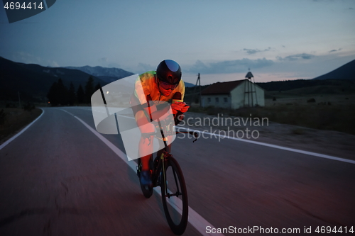 Image of triathlon athlete riding bike at night
