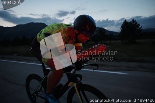 Image of triathlon athlete riding bike at night