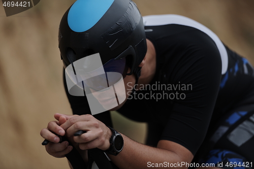 Image of triathlon athlete riding a bike wearing black