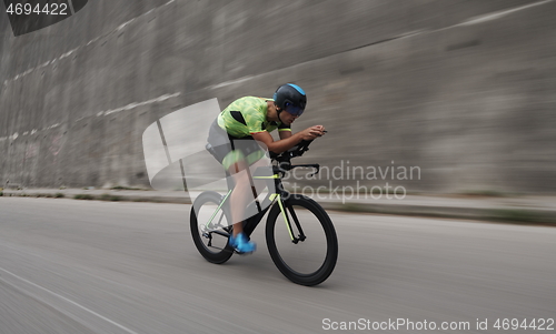 Image of triathlon athlete riding a bike on morning training