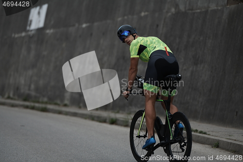 Image of triathlon athlete riding a bike on morning training