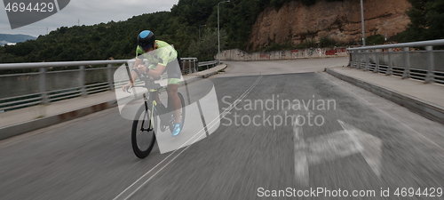 Image of triathlon athlete riding a bike on morning training