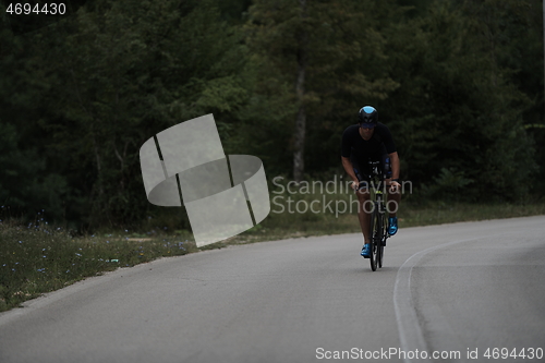 Image of triathlon athlete riding a bike wearing black