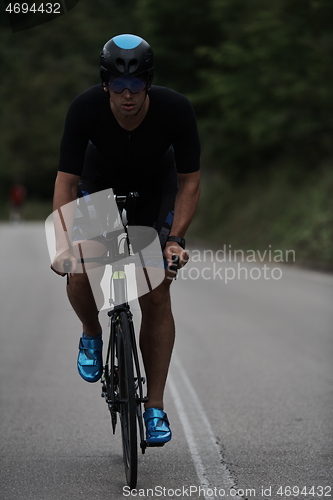 Image of triathlon athlete riding a bike wearing black