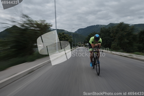 Image of triathlon athlete riding a bike on morning training