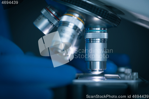 Image of Sample slide and microscope with metal lens at laboratory.