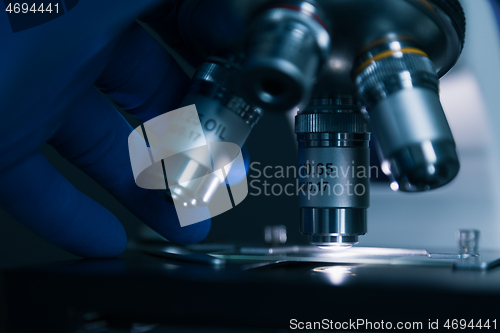 Image of Sample slide and microscope with metal lens at laboratory.