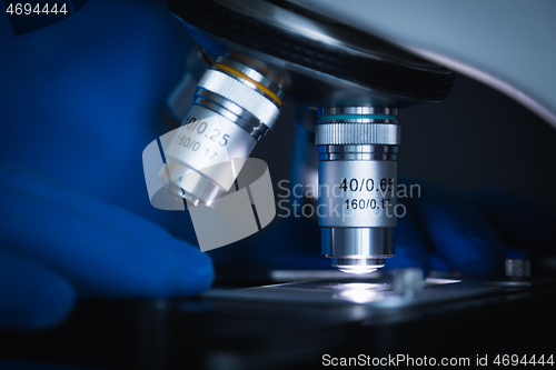 Image of Sample slide and microscope with metal lens at laboratory.