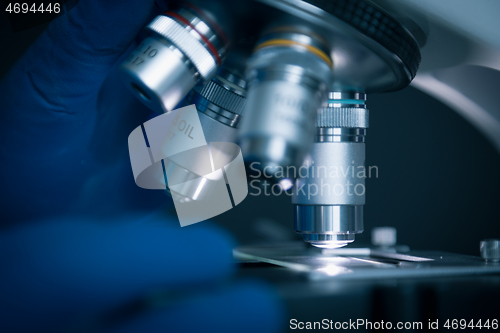 Image of Sample slide and microscope with metal lens at laboratory.