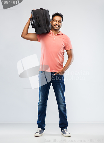 Image of smiling indian man with travel bag on shouder