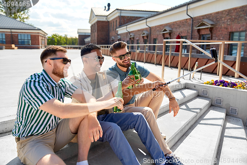 Image of men drinking beer and taking selfie by smartphone