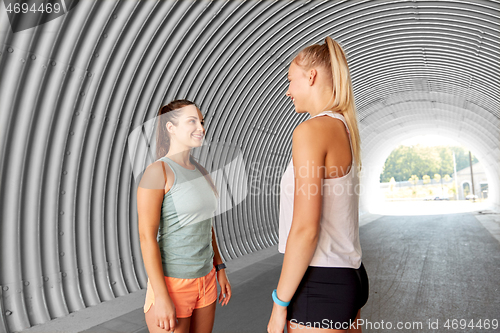 Image of sporty young women or female friends in tunnel