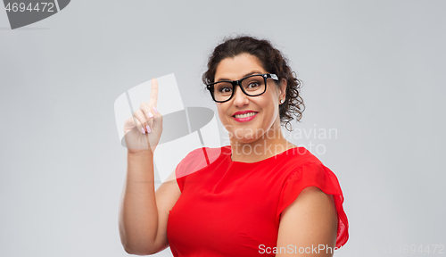 Image of happy woman in glasses pointing finger up