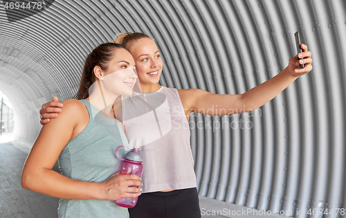 Image of sporty women taking selfie by smartphone outdoors