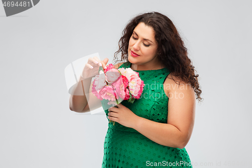 Image of happy woman in green dress with flower bunch