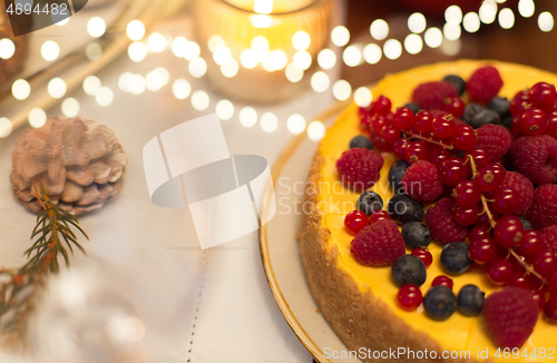 Image of close up of berry cake on christmas table at home