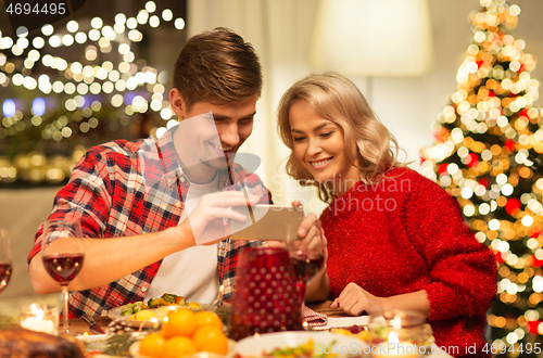 Image of couple with smartphone at home christmas dinner