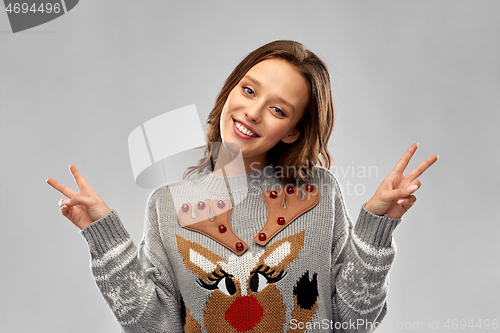 Image of woman in ugly christmas sweater showing peace sign