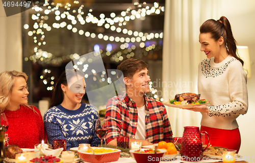 Image of happy friends having christmas dinner at home