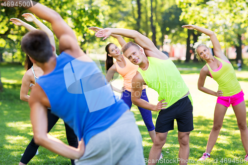 Image of group of happy people exercising at summer park