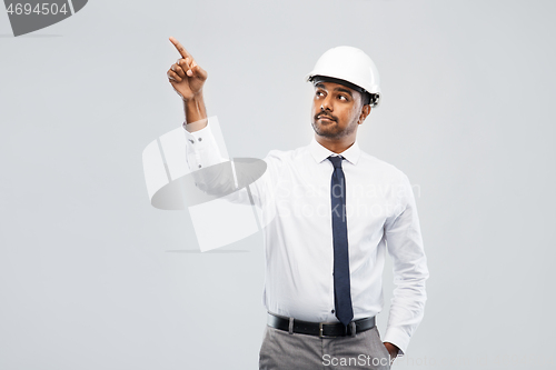 Image of indian male architect in helmet showing something