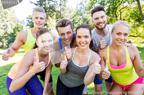 Image of group of happy sporty friends showing thumbs up