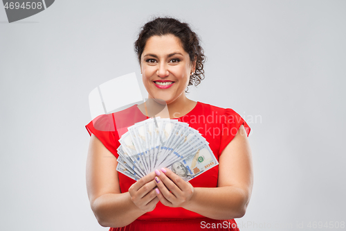 Image of happy woman holding hundreds of money banknotes