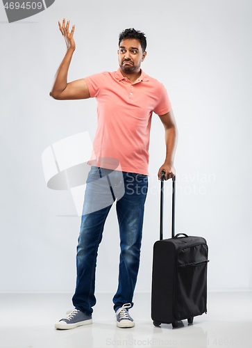 Image of indian man in polo shirt with travel bag shrugging